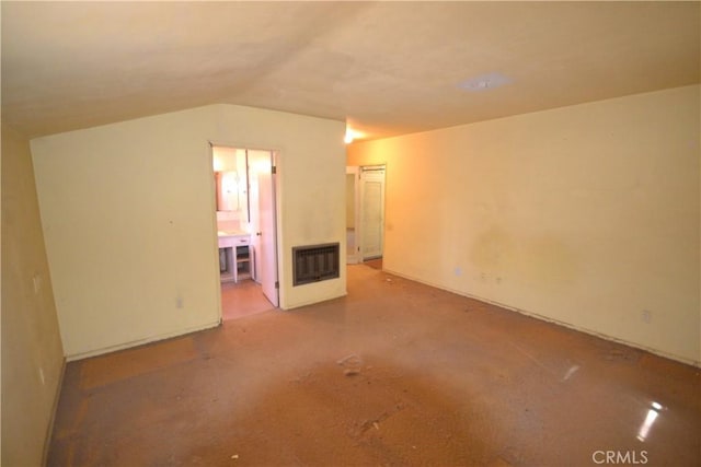 unfurnished room with lofted ceiling, heating unit, and a fireplace