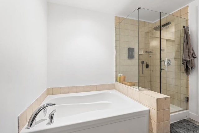 bathroom featuring a bath and a shower stall