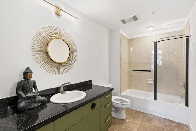 bathroom featuring toilet, stone tile floors, visible vents, vanity, and tub / shower combination