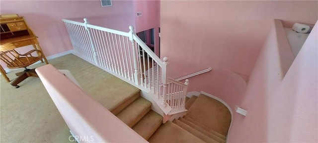 staircase with carpet flooring, visible vents, and baseboards