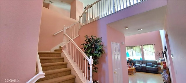 stairway featuring a high ceiling and visible vents