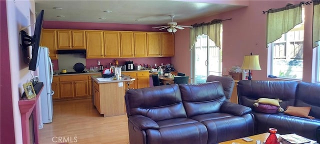 kitchen featuring a center island, open floor plan, light countertops, and under cabinet range hood