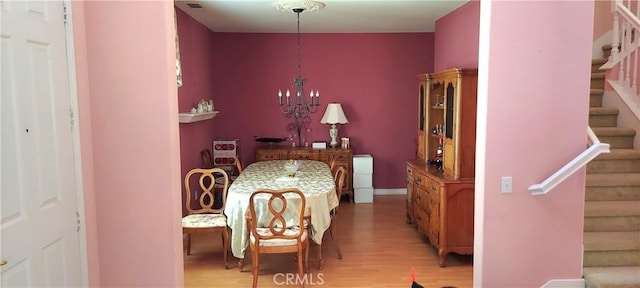 bedroom featuring a chandelier, visible vents, fridge, and light wood-style flooring