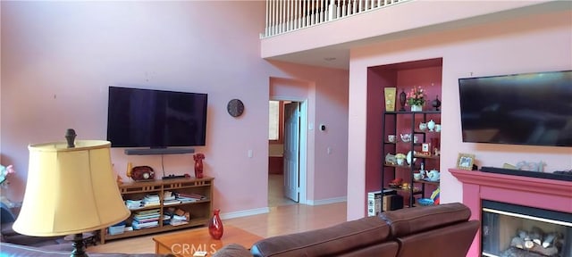 living area featuring a glass covered fireplace and baseboards