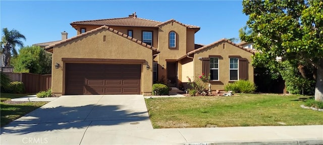 mediterranean / spanish home with a garage, fence, concrete driveway, stucco siding, and a front yard