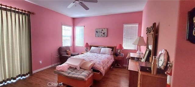 bedroom with dark wood-style floors, baseboards, and a ceiling fan