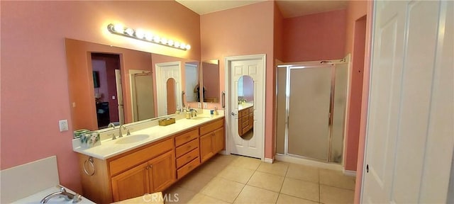 bathroom featuring double vanity, a stall shower, tile patterned flooring, and a sink