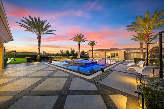 view of swimming pool featuring an infinity pool, a patio area, a jacuzzi, and fence