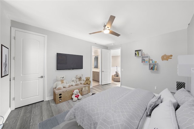 bedroom featuring connected bathroom, ceiling fan, baseboards, and wood finished floors