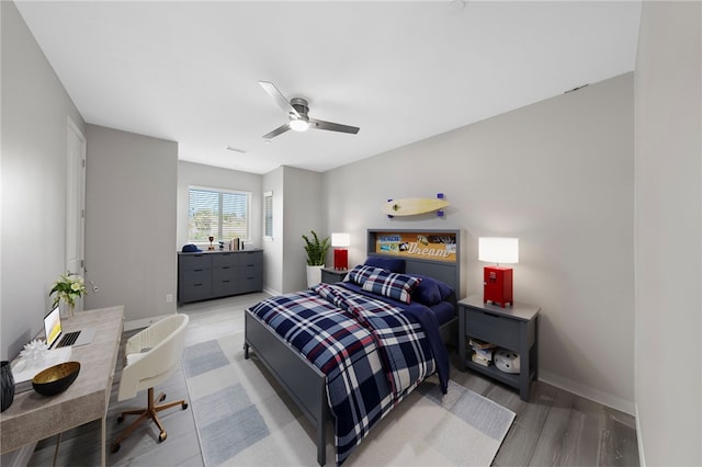 bedroom featuring visible vents, wood finished floors, a ceiling fan, and baseboards