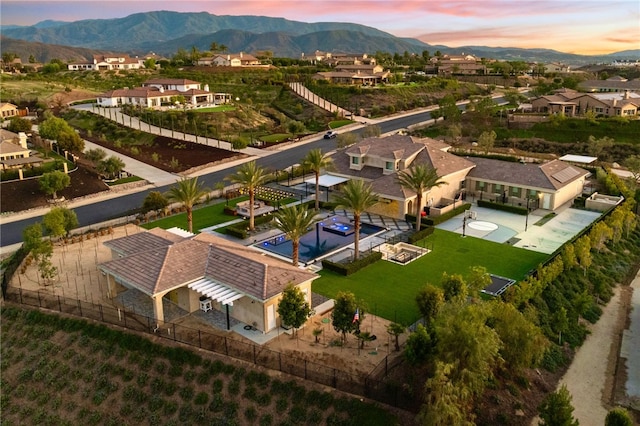 aerial view at dusk featuring a residential view and a mountain view