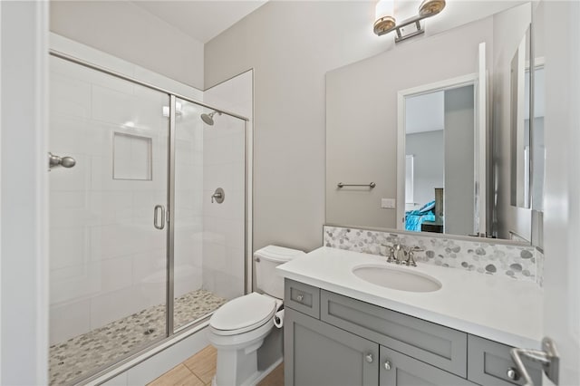 ensuite bathroom featuring a stall shower, vanity, toilet, and ensuite bathroom