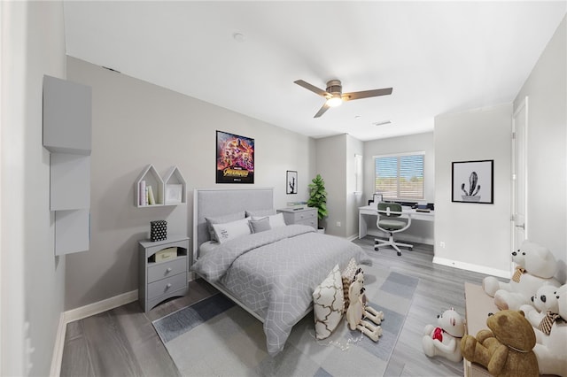 bedroom with ceiling fan, wood finished floors, visible vents, and baseboards