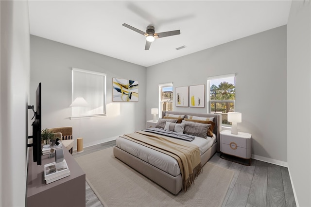 bedroom featuring visible vents, ceiling fan, baseboards, and wood finished floors