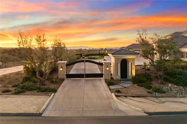 view of front of house featuring fence, driveway, a tiled roof, a gate, and stucco siding