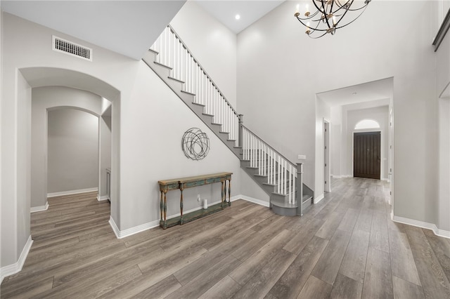 entrance foyer featuring baseboards, stairs, visible vents, and wood finished floors