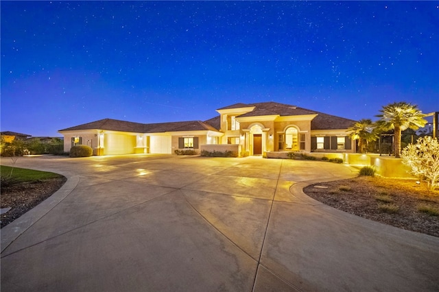 mediterranean / spanish house featuring curved driveway and an attached garage