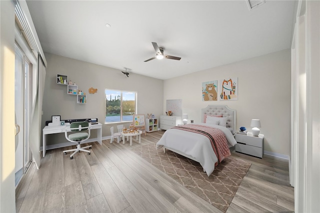 bedroom featuring wood finished floors, visible vents, and baseboards