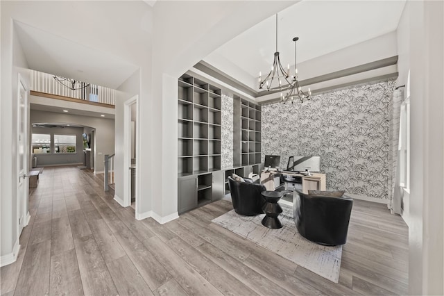 home office with a chandelier, light wood-type flooring, baseboards, and wallpapered walls