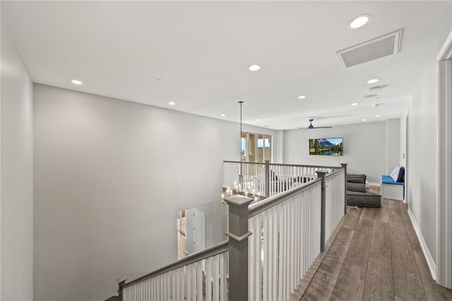 hall featuring wood finished floors, an upstairs landing, and recessed lighting