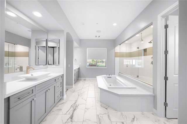 full bathroom with a stall shower, a garden tub, a sink, and baseboards