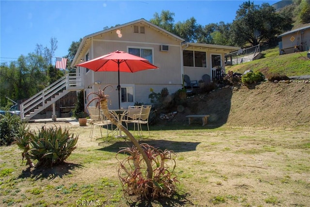 rear view of house with a lawn, stairway, and a patio