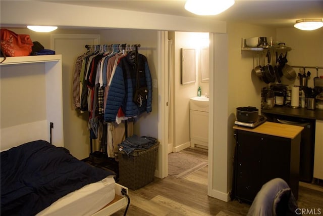 bedroom with ensuite bathroom and wood finished floors