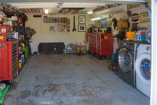 garage with washing machine and dryer and a workshop area