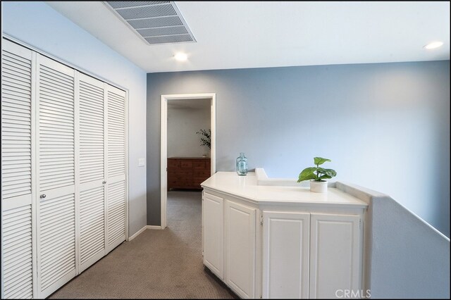 corridor with recessed lighting, baseboards, visible vents, and carpet flooring