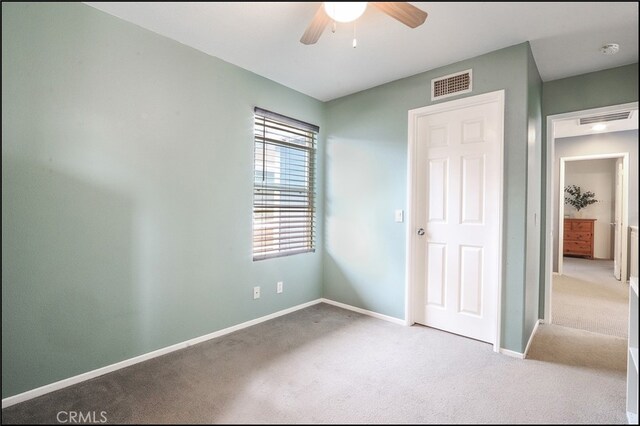 unfurnished bedroom featuring carpet, visible vents, and baseboards