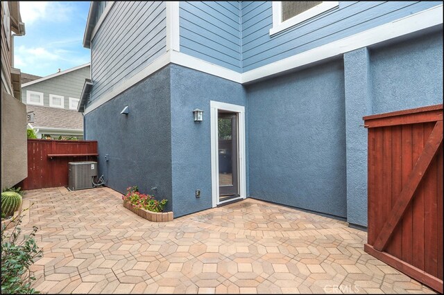 exterior space featuring central AC unit and fence