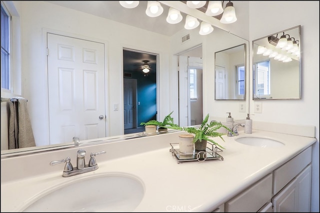 bathroom with visible vents, a sink, and double vanity