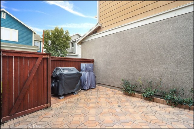 view of patio with a grill and fence