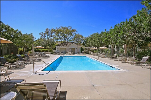 community pool featuring fence and a patio