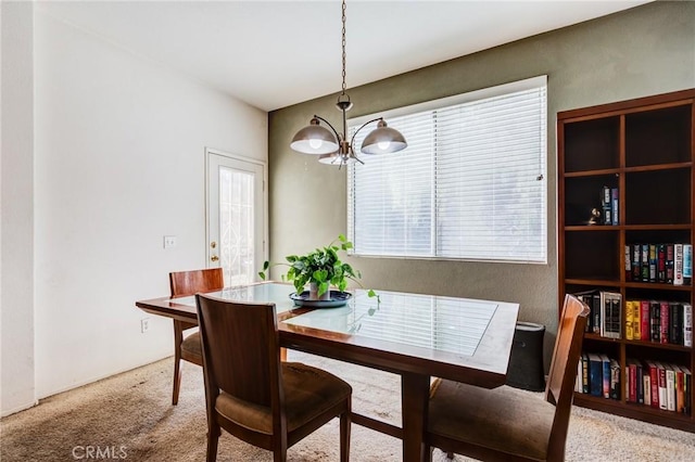 dining room featuring a chandelier and carpet