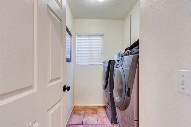 washroom featuring laundry area, washer and clothes dryer, and light tile patterned floors