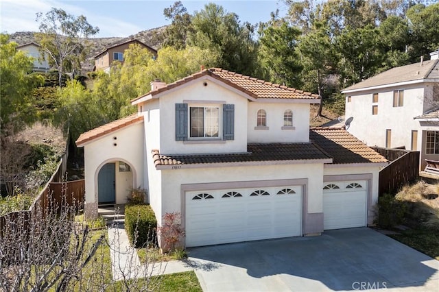 mediterranean / spanish-style home with concrete driveway, a tiled roof, and stucco siding