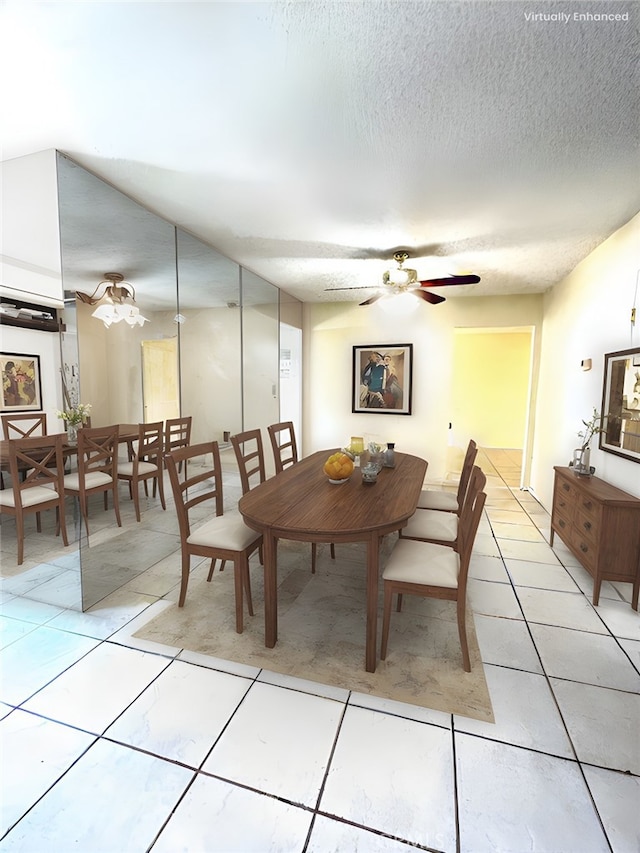 dining area with a textured ceiling, light tile patterned floors, and a ceiling fan