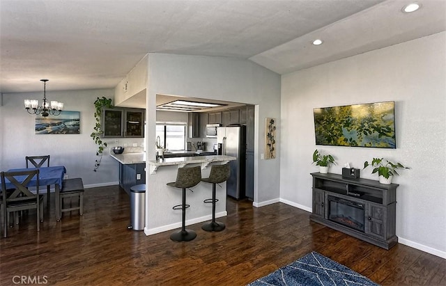 kitchen featuring appliances with stainless steel finishes, vaulted ceiling, and dark wood-style floors