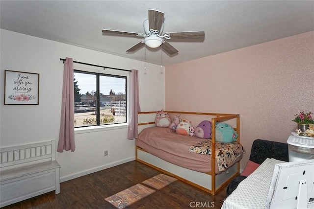 bedroom featuring dark wood-style floors, a ceiling fan, and baseboards