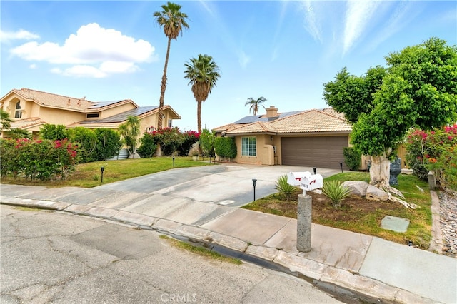 68820 San Felipe Rd, Cathedral City, CA 92234 - view of front facade with stucco siding, driveway, a garage, solar panels, and a tile roof
