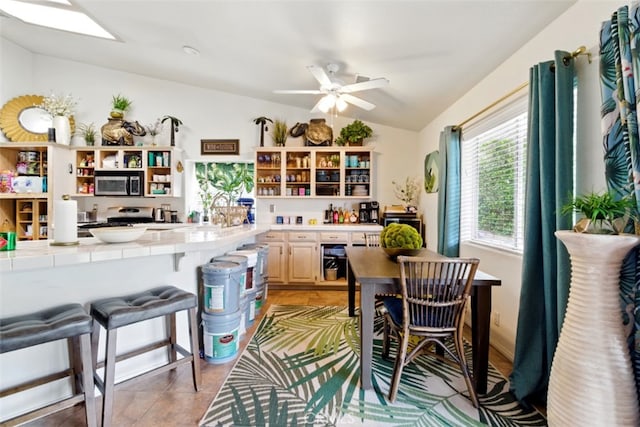 68820 San Felipe Rd, Cathedral City, CA 92234 - kitchen featuring open shelves, stainless steel microwave, tile countertops, lofted ceiling, and ceiling fan