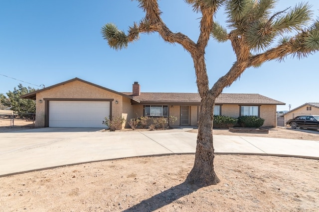 ranch-style house featuring driveway, a chimney, an attached garage, and stucco siding