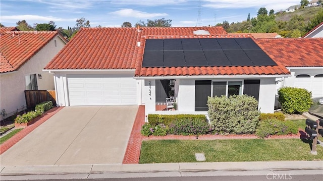 mediterranean / spanish home featuring a garage, stucco siding, and a tiled roof