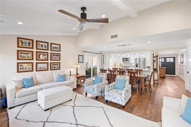 living area featuring vaulted ceiling with beams, plenty of natural light, visible vents, and wood finished floors