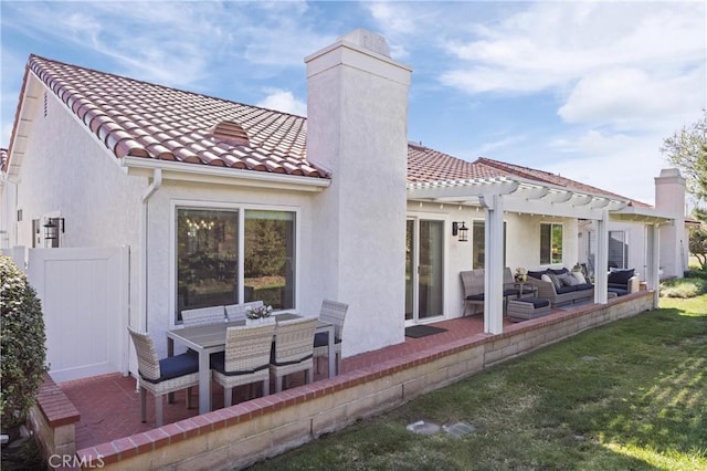 rear view of property featuring a patio, a tiled roof, a lawn, a pergola, and a chimney