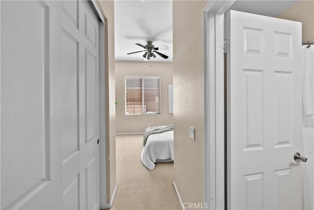 corridor with light colored carpet and baseboards