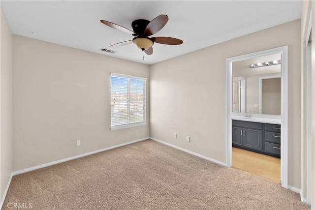 unfurnished bedroom with ceiling fan, connected bathroom, light carpet, visible vents, and baseboards