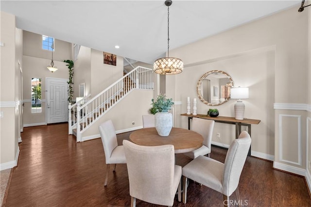 dining area with wood finished floors, baseboards, and stairs