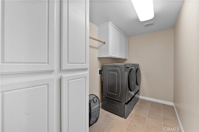 laundry room with light tile patterned floors, separate washer and dryer, visible vents, baseboards, and cabinet space